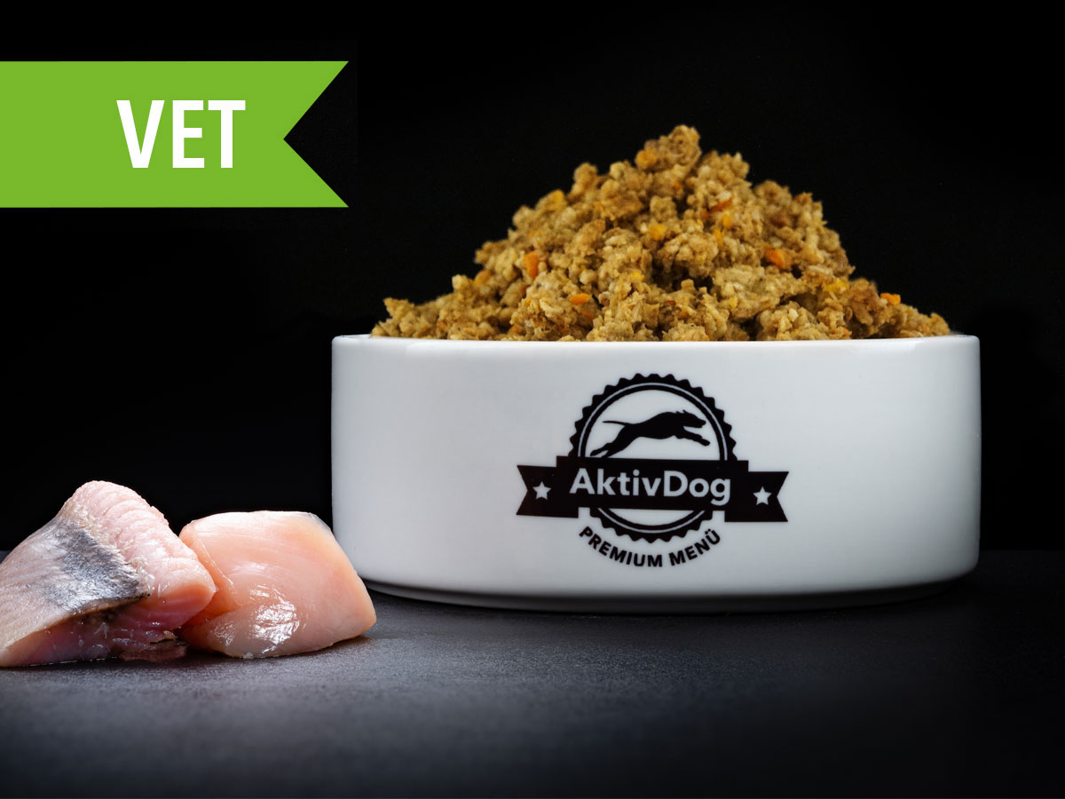 Großaufnahme von AktivDog Hundefutter VET fettarm mit links daneben liegendem rohen Schweizer Egli