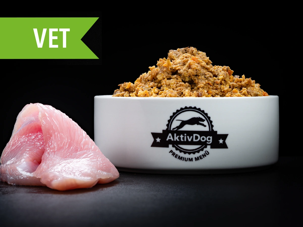 Großaufnahme von AktivDog Hundefutter VET Schonkost mit links daneben liegendem rohen Schweizer Trutenfleisch