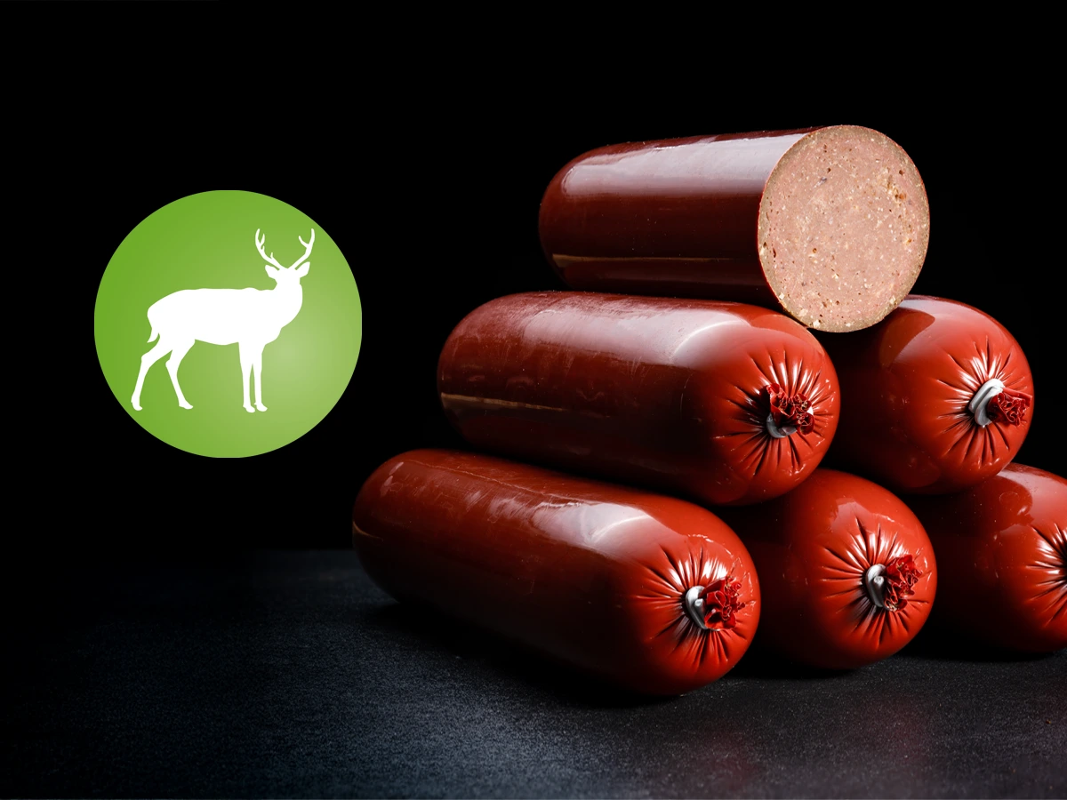 AktivDog schnittfeste Trainingswürste Wild, lecker und kräftig im Geschmack, liegen pur auf einem dunklen Untergrund
